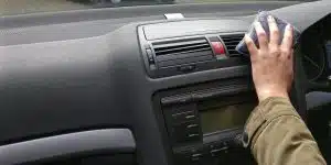 Auto Innenraum Cockpit reinigen mit Schwamm Frauen Hand Lenkrad